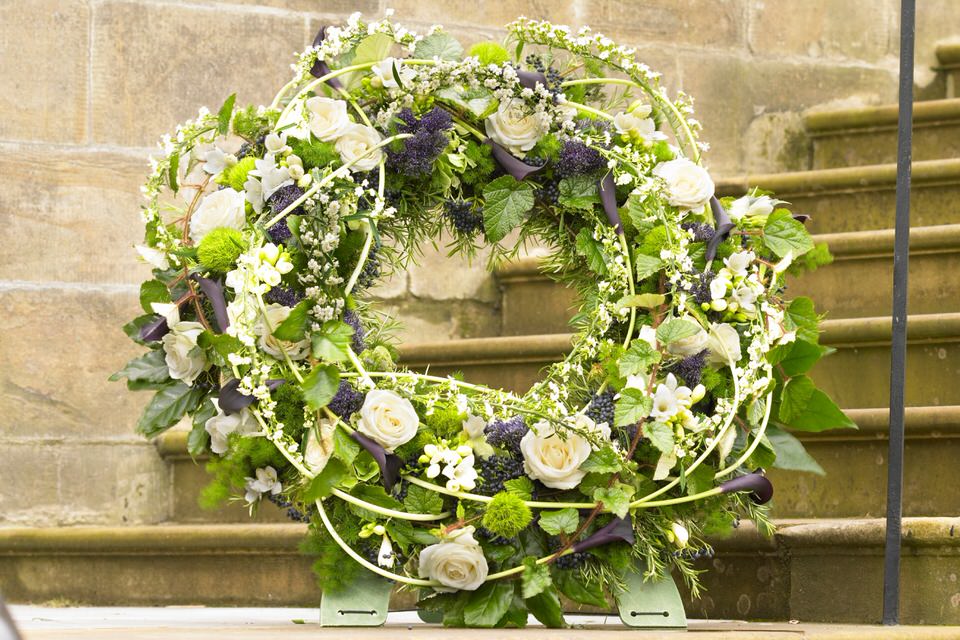 <h2>Deluxe Extra Large White Standing Wreath | Funeral Flowers</h2>
<ul>
<li>Approximate Size W 60cm H 60cm on stand (extra large)</li>
<li>Hand created deluxe white wreath in fresh flowers</li>
<li>To give you the best we may occasionally need to make substitutes</li>
<li>Funeral Flowers will be delivered at least 2 hours before the funeral</li>
<li>For delivery area coverage see below</li>
</ul>
<br>
<h2>Liverpool Flower Delivery</h2>
<p>We have a wide selection of Funeral Wreaths offered for Liverpool Flower Delivery. Funeral Wreaths can be provided for you in Liverpool, Merseyside and we can organize Funeral flower deliveries for you nationwide. Funeral Flowers can be delivered to the Funeral directors or a house address. They can not be delivered to the crematorium or the church.</p>
<br>
<h2>Flower Delivery Coverage</h2>
<p>Our shop delivers funeral flowers to the following Liverpool postcodes L1 L2 L3 L4 L5 L6 L7 L8 L11 L12 L13 L14 L15 L16 L17 L18 L19 L24 L25 L26 L27 L36 L70 If your order is for an area outside of these we can organise delivery for you through our network of florists. We will ask them to make as close as possible to the image but because of the difference in stock and sundry items it may not be exact.</p>
<br>
<h2>Liverpool Funeral Flowers | Wreaths</h2>
<p>This striking extra special deluxe standing wreath design has been loving handcrafted by our florists and features large-headed white roses and freesias which are nestled amongst contrasting dark calla lilies along with luscious green foliages in this circular extra large standing wreath.</p>
<br>
<p>A funeral wreath is flowers arranged in a circular shape with a hole in the centre. This circular shape symbolises the circle of life or eternal life. They are suitable for sending directly to a funeral whether you are family or a friend.</p>
<br>
<p>Contents of 24 inch oasis ring: 12 white large-headed roses, 10 schwarzwalder calla lilies, 10 white freesias, 5 trachelium, 5 Euphorbia fulgens, 5 dianthus barbatus and mixed foliage including ivy trails, asparagus, rosemary and fatsia aralia.</p>
<br>
<h2>Best Florist in Liverpool</h2>
<p>Trust Award-winning Liverpool Florist, Booker Flowers and Gifts, to deliver funeral flowers fitting for the occasion delivered in Liverpool, Merseyside and beyond. Our funeral flowers are handcrafted by our team of professional fully qualified who not only lovingly hand make our designs but hand-deliver them, ensuring all our customers are delighted with their flowers. Booker Flowers and Gifts your local Liverpool Flower shop.</p>
<br>
<p><em>Jane Catherine and Family - Review by Post - Funeral Florist Liverpool</em></p>
<br>
<p><em>Thank you so much for the amazing flowers you arranged for our mum she would have loved them. Love Jane, Catherine and family</em></p>
<br>
